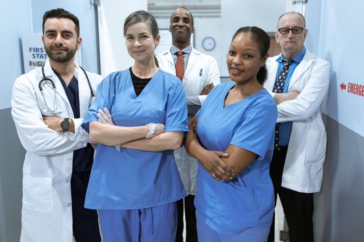 Equipe de médicos e enfermeiros sorrindo no corredor do hospital